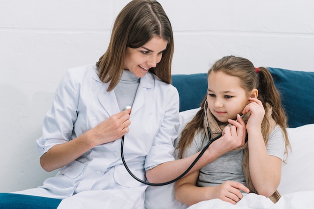 Premium Photo Sick Girl Listening The Heart Beat Of Smiling Female Doctor With Stethoscope