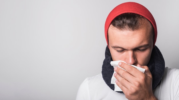 Sick woman coughing covering her mouth against gray background | Free Photo