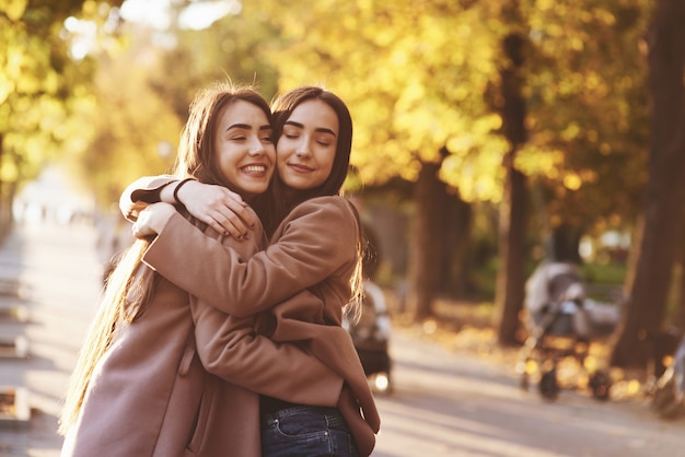 Premium Photo | Side profile of young smiling brunette twin girls ...