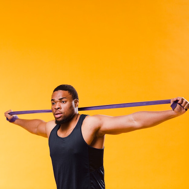 Free Photo | Side view of athletic man pulling resistance band