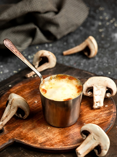 Free Photo Side View Of Baked Mushroom Julienne With Chicken And Cheese In A Small Bowl On Wooden Board