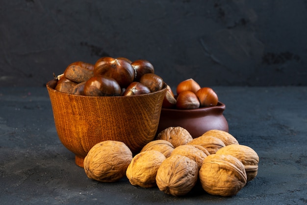 Castagne vista laterale in una tazza con nocciole e noci | Foto Gratis