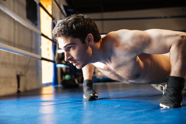 Premium Photo | Side view of concentrated boxer doing push ups