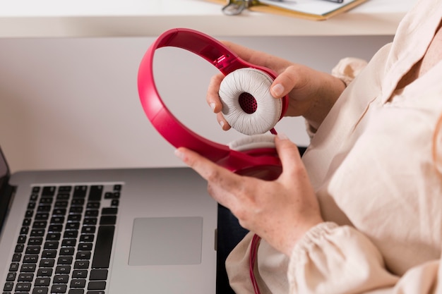 Side view of female teacher holding headphones and laptop for online class Free Photo