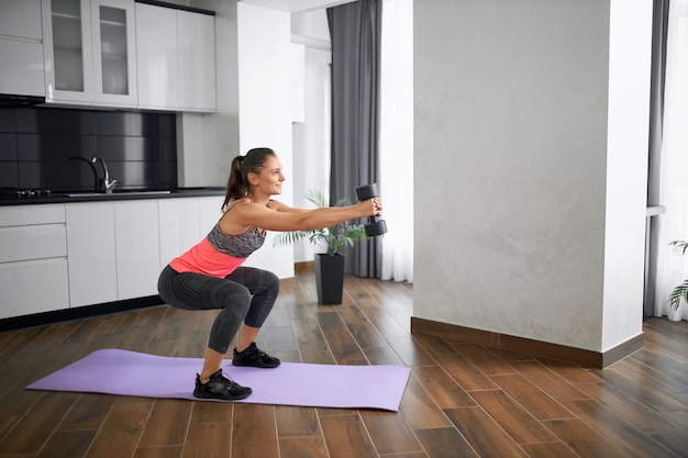 Premium Photo | Side view of fit caucasian young woman squatting in ...