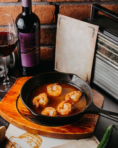 Free Photo | Side view of fried shrimp with sauce on a black pan