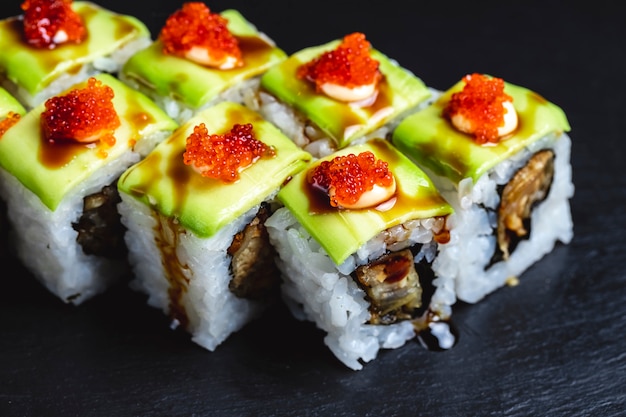 Side view green dragon roll with fried fish avocado soy