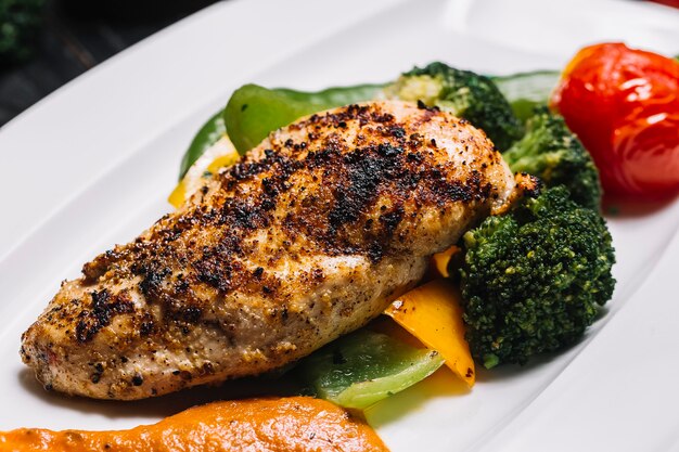 Free Photo | Side view grilled chicken breast with broccoli bell pepper ...