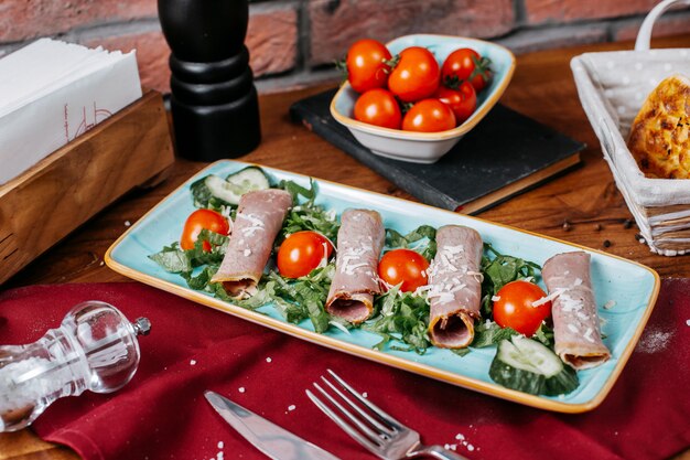 Free Photo | Side view of ham roll withj tomatoes and cucumbers on a plate