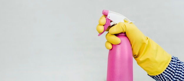 Free Photo | Side view of hand in rubber glove holding cleaning product