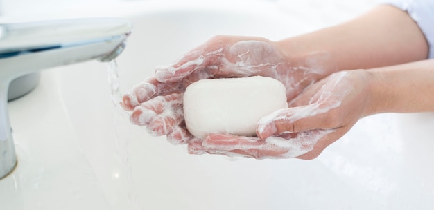 Side view of hands using bar of soap to wash Free Photo