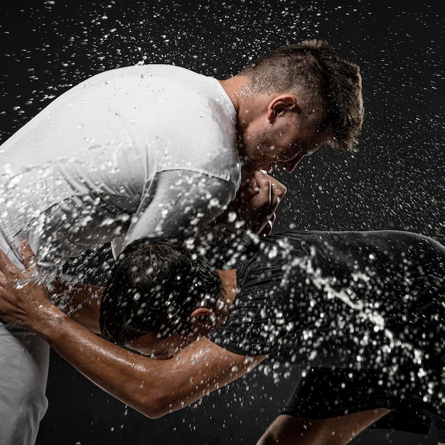 Free Photo | Side View Of Male Rugby Players With Ball And Water Splashes