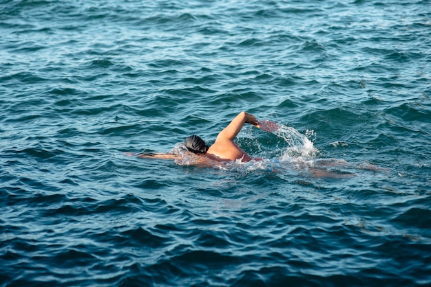 Premium Photo | Side view of male swimmer swimming in water