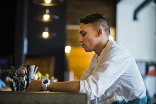 Free Photo | Side view of a man holding glass of drink in the restaurant