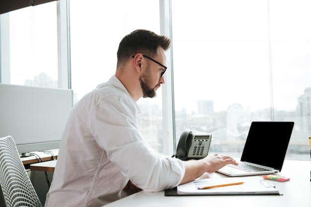 Premium Photo | Side view of man using laptop