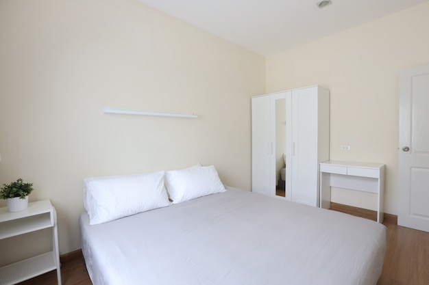 Side View Of New Modern White Wooden Bed In White Bedroom