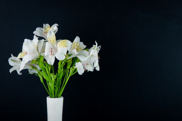 コピースペースと黒の背景に白い花瓶の白い色アルストロメリアの花の花束の側面図 無料の写真