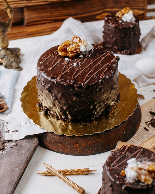テーブルの上のチョコレートとクルミで覆われたケーキの側面図 無料の写真