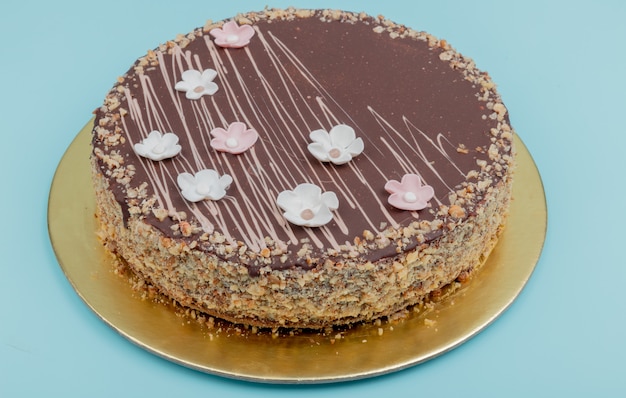 青い表面上のナッツとチョコレートケーキの側面図 無料の写真