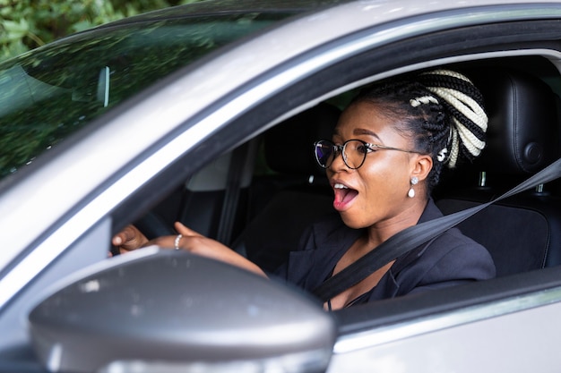 彼女の個人的な車を運転することに興奮している女性の側面図 無料の写真