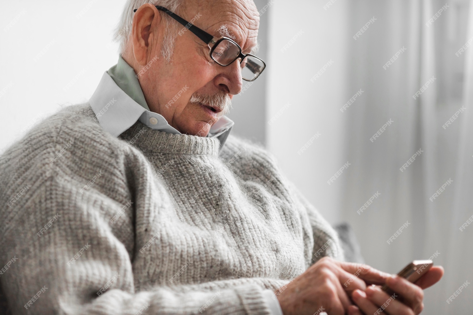 Free Photo | Side view of old man in a nursing home using smartphone