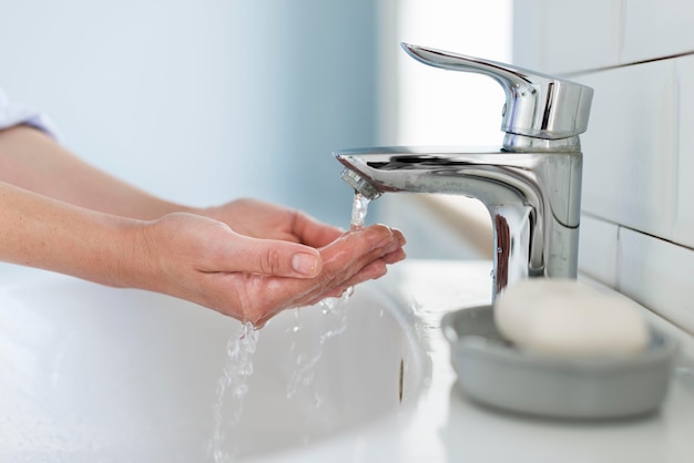 Side view of person washing their hands with water Free Photo