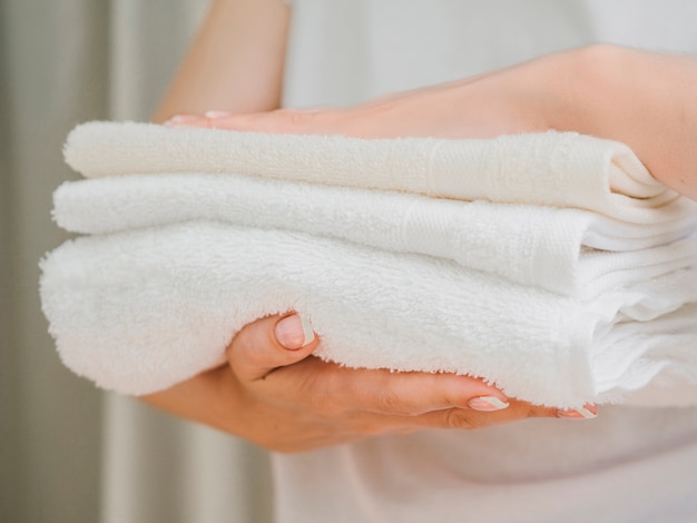 Free Photo | Side view pile of towels between hands