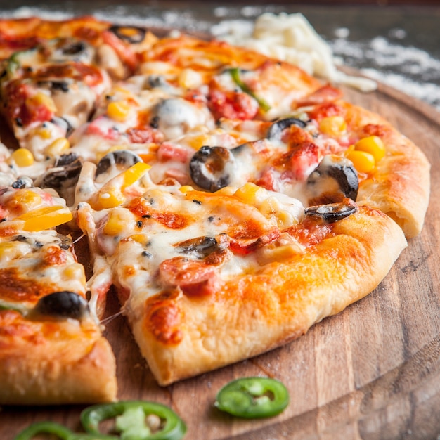 Free Photo Side view pizza with chopped pepper in board cookware