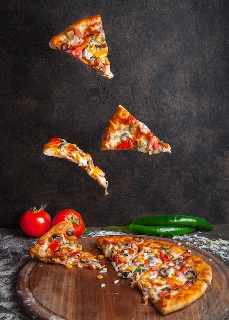 Free Photo Side view pizza with pepper and tomato and pizza slices in