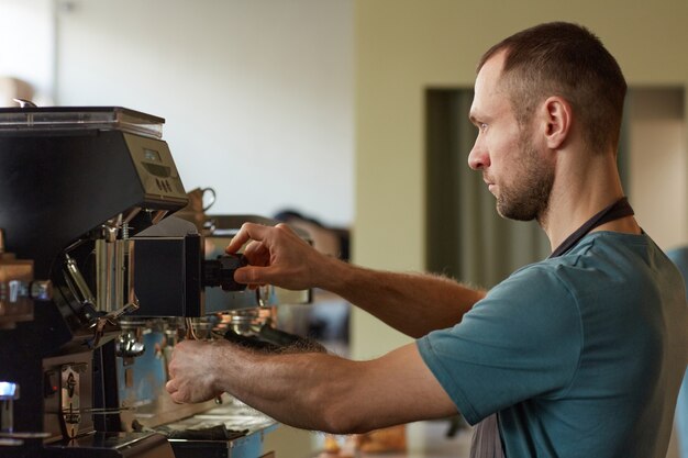 premium-photo-side-view-portrait-of-male-barista-making-fresh-coffee