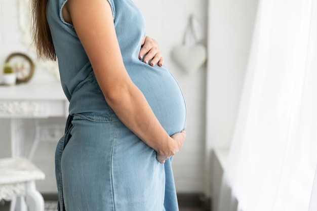 Side view pregnant woman wearing a blue dress Free Photo