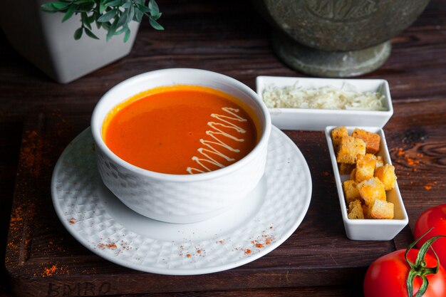 Free Photo | Side view tomato soup on wooden table