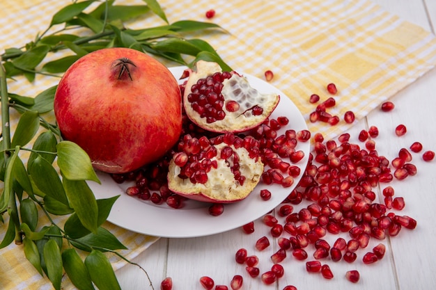 Free Photo | Side view of whole pomegranate and pomegranate pieces with ...