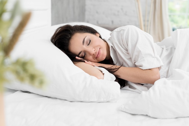 Side view of woman sleeping in bed Free Photo