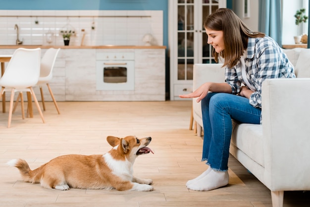 Side view of woman telling her dog to sit | Free Photo