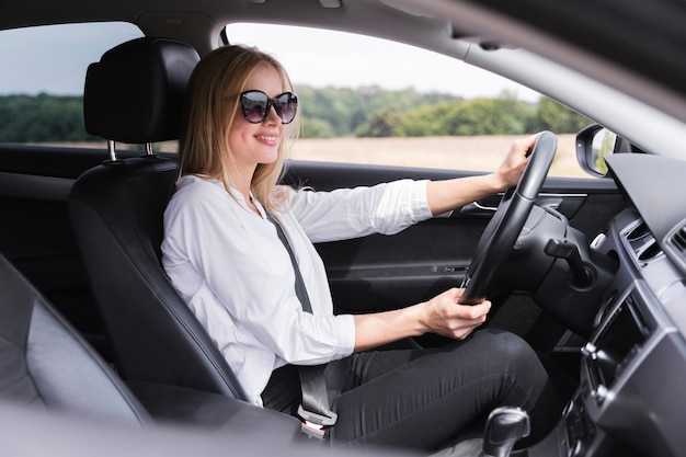 Side view of woman with sunglasses driving Free Photo