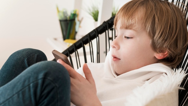 Free Photo | Side view of young boy using smartphone