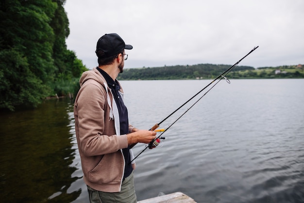 Free Photo | Side view of young man holding fishing rod