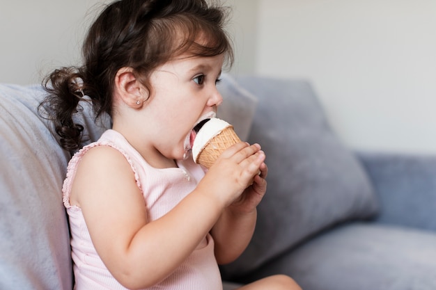 アイスクリームを食べる横顔の女の赤ちゃん 無料の写真