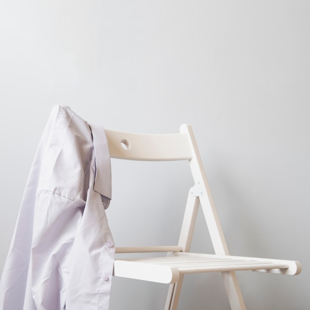 白い椅子に横向きのシャツ 無料の写真