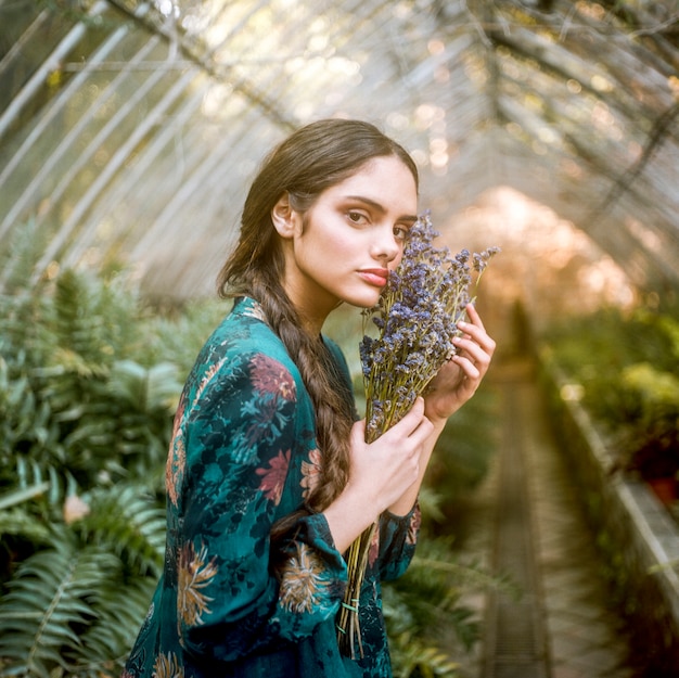 Sideways woman holding lavender flowers Free Photo