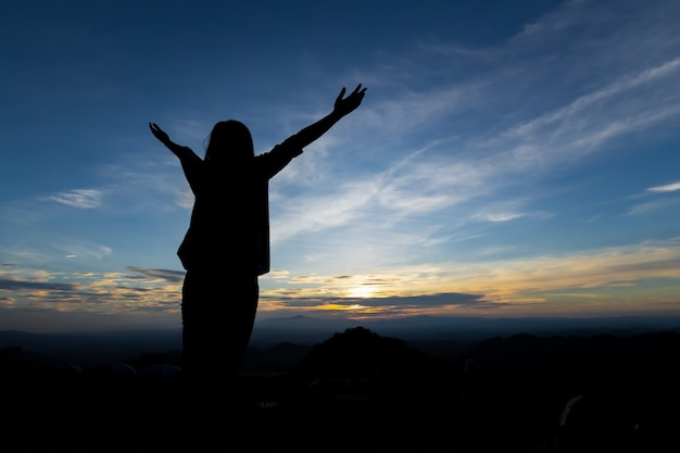 Premium Photo | Silhouette of asian woman raise her arms looking at the ...