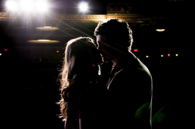 Silhouette of couple kissing while standing on the stage
