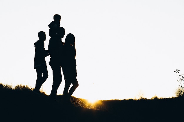 Silhouette of a family walking by the sunset time Free Photo