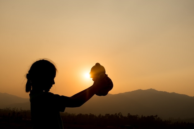 Premium Photo Silhouette Of Girl Standing Alone And Hand Holding Teddy Bear At A Sunset Time