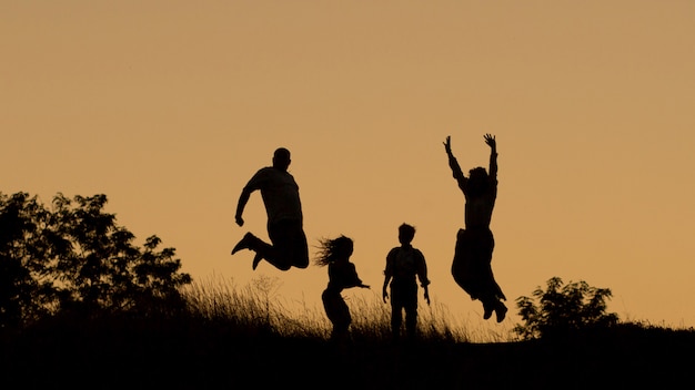 Premium Photo | Silhouette of a happy family of four, mother, father ...