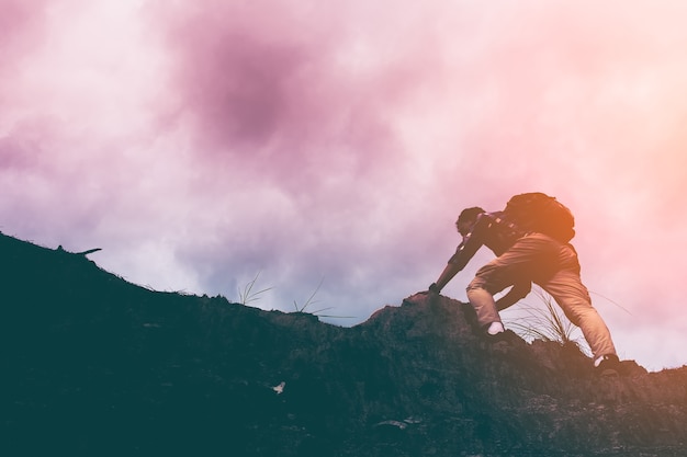 Silhouette of man climbing steep mountain. good image for adventure ...