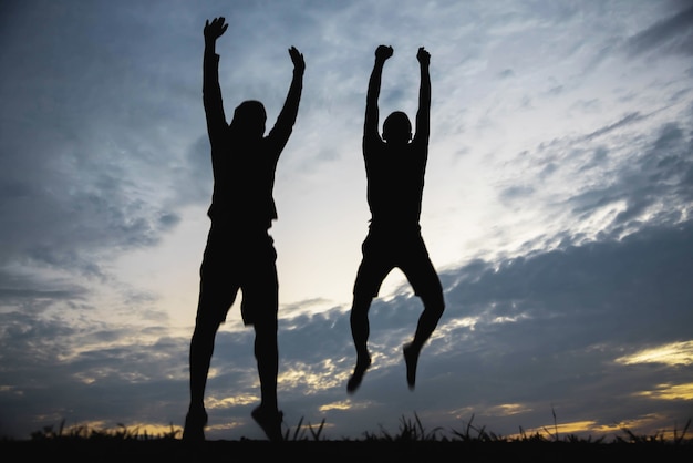 Premium Photo | Silhouette of a man jumping with happy in the sunset.