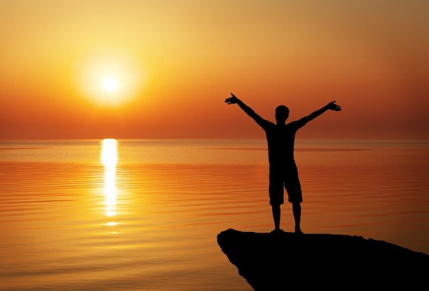 Premium Photo | Silhouette of a man on a mountain top on sunset background