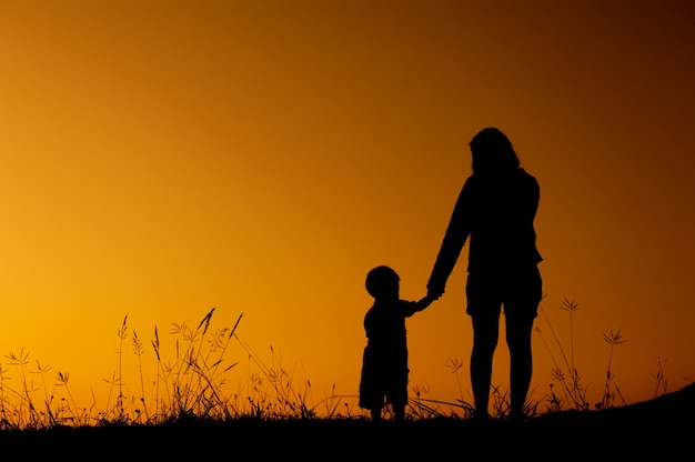 Silhouette Of A Mother And Son Playing In Sunset Premium Photo